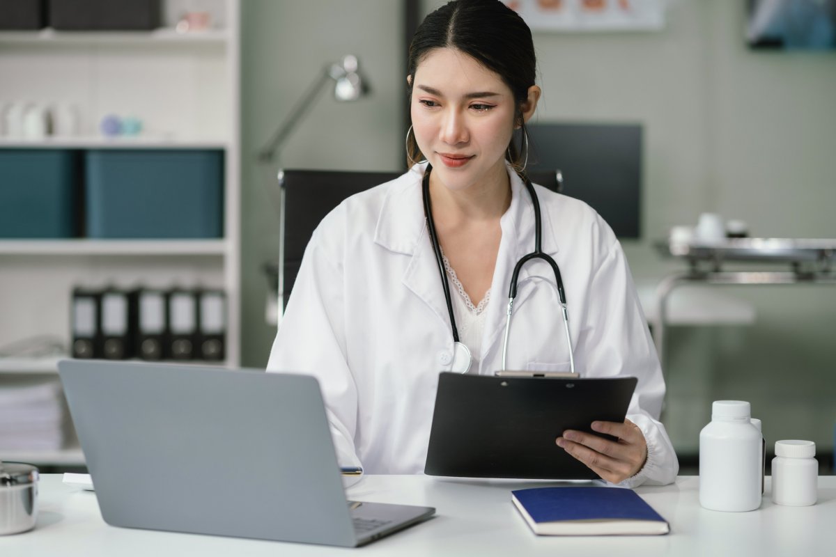 Doctor working on laptop computer and tablet